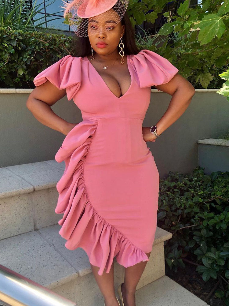 woman in a pink ruffled dress with hands on hips