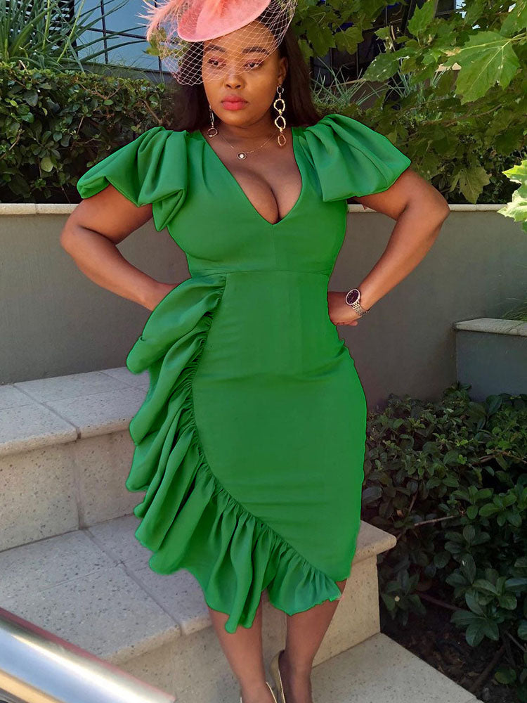 woman wearing a green ruffled dress and a fascinator