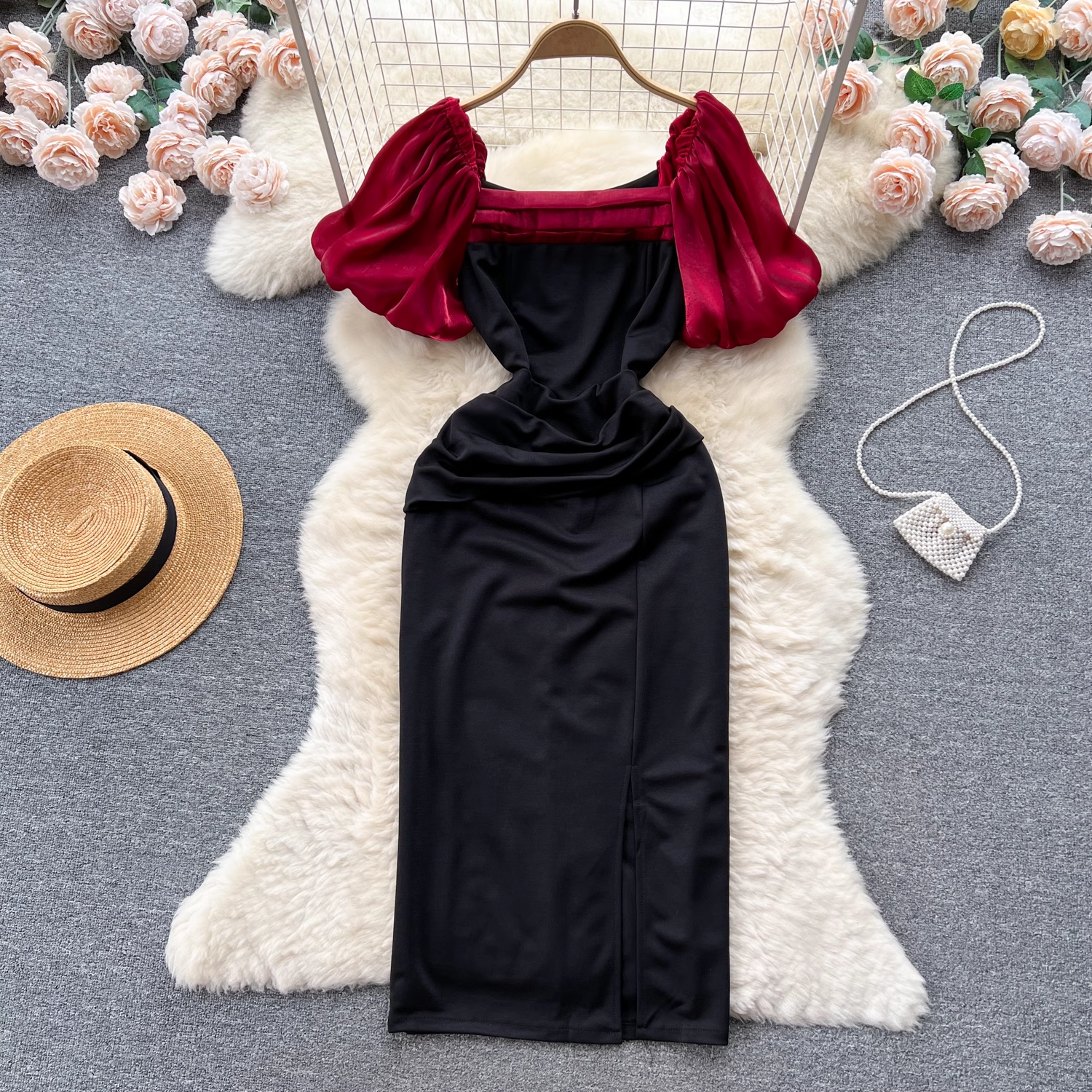 Full view of the black and red puff sleeve dress with a slit