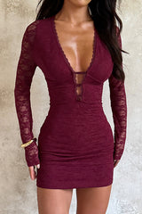 Full-body shot of a woman in a burgundy lace bodycon dress.