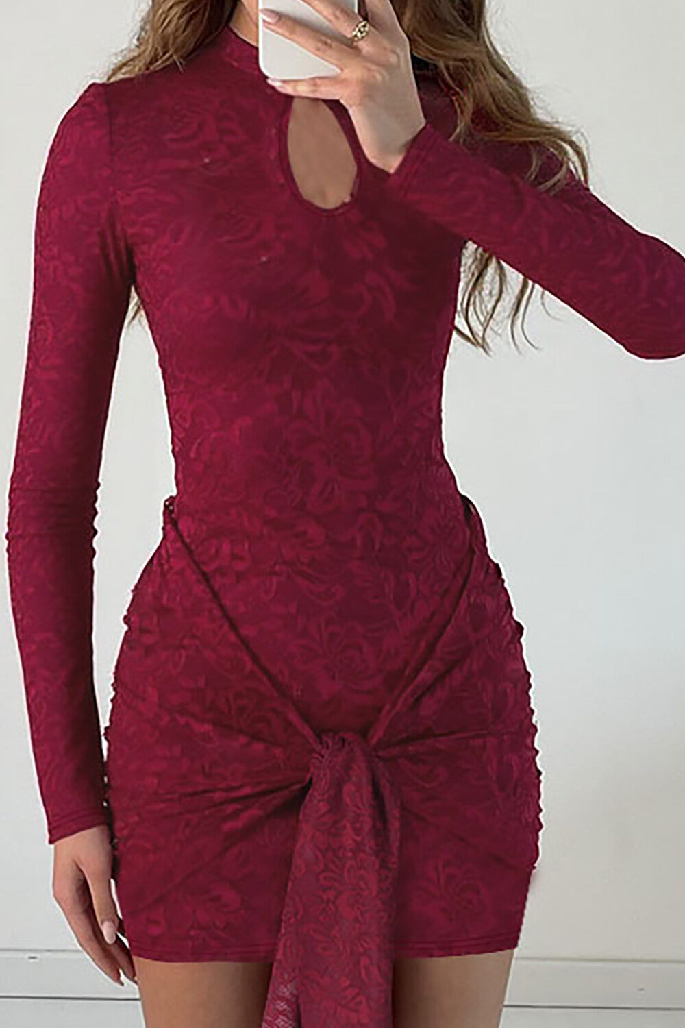 Full shot of a maroon lace mini dress with a keyhole neckline and a tie detail, displayed on a mannequin.