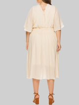 Plus-size woman wearing a cream midi dress with flutter sleeves and a smocked waist, shown from the back.