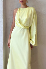 Close-up of the draped bodice and asymmetrical sleeve of a pale yellow satin one-shoulder maxi dress on a model.