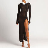 Woman in a black, sheer, ribbed, long-sleeved maxi dress with a white collared neckline and a high slit.