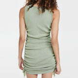 back view of a model wearing a light green ruched knit dress