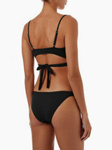 Back view of a woman wearing a black bikini with a crisscross halter top and double strap bottoms