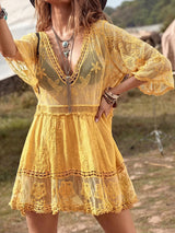 Woman wearing a yellow lace cover-up with a V-neckline and tiered skirt.