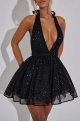 woman posing in a black sparkly halter dress