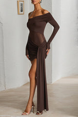 Front three-quarter view of a woman in a brown off-the-shoulder ruched mini dress with a draped accent and long sleeves.