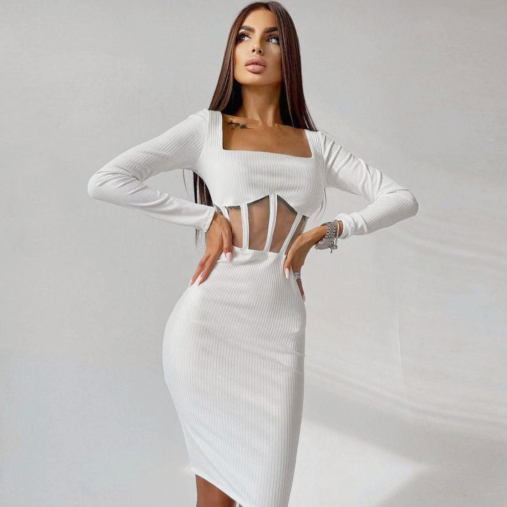 Full body shot of a woman in a white ribbed knit dress with sheer midriff details.