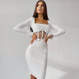 Full body shot of a woman in a white ribbed knit dress with sheer midriff details.
