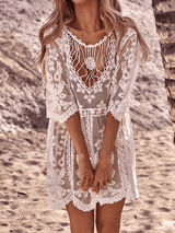 Close-up of the detailed crochet neckline of a white lace beach cover-up