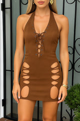 Woman wearing a brown halter neck mini dress with lace-up detail and cut-outs