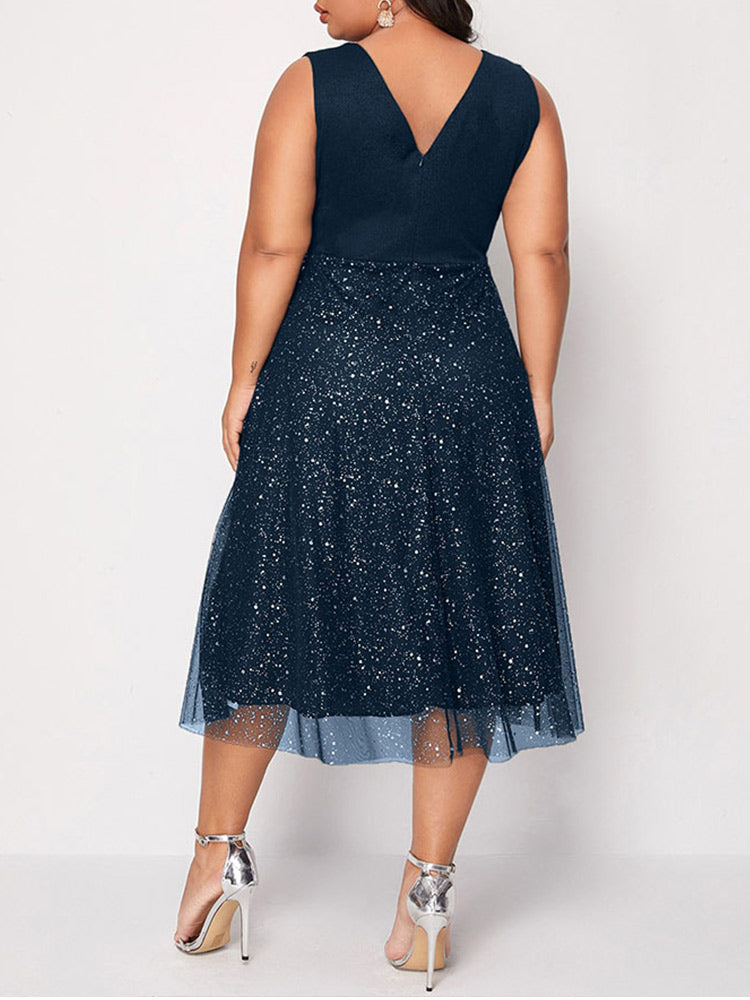 Back view of a woman in a navy blue sleeveless V-neck midi dress with sparkly embellishments and a tulle overlay.