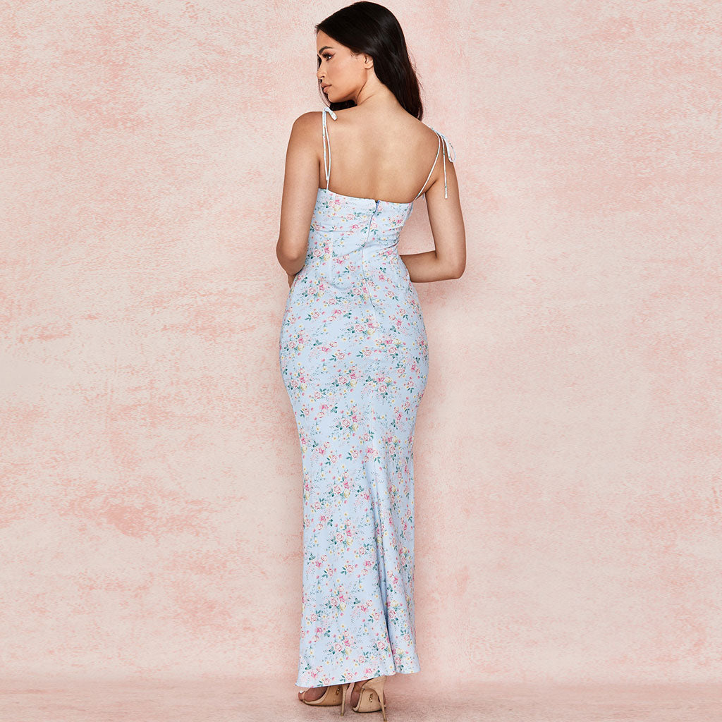 back view of a woman in a light blue floral print maxi dress