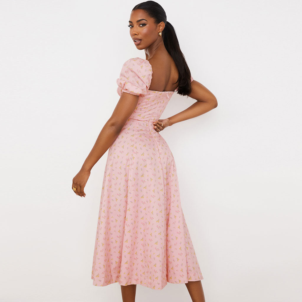 back view of a woman in a pink floral midi dress with puff sleeves