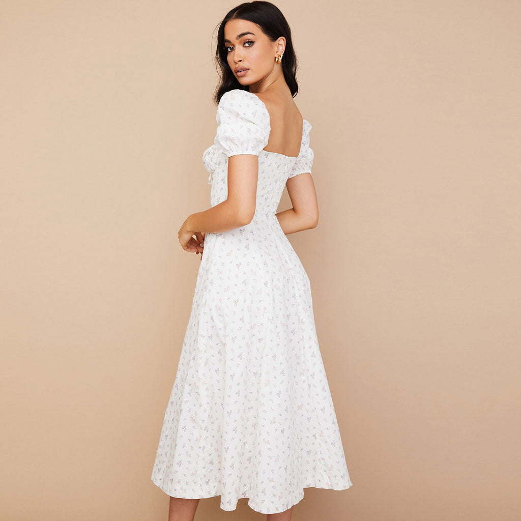 Rear view of a woman in a white floral midi dress with puff sleeves