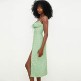 Side view of a woman in a green floral print midi dress.