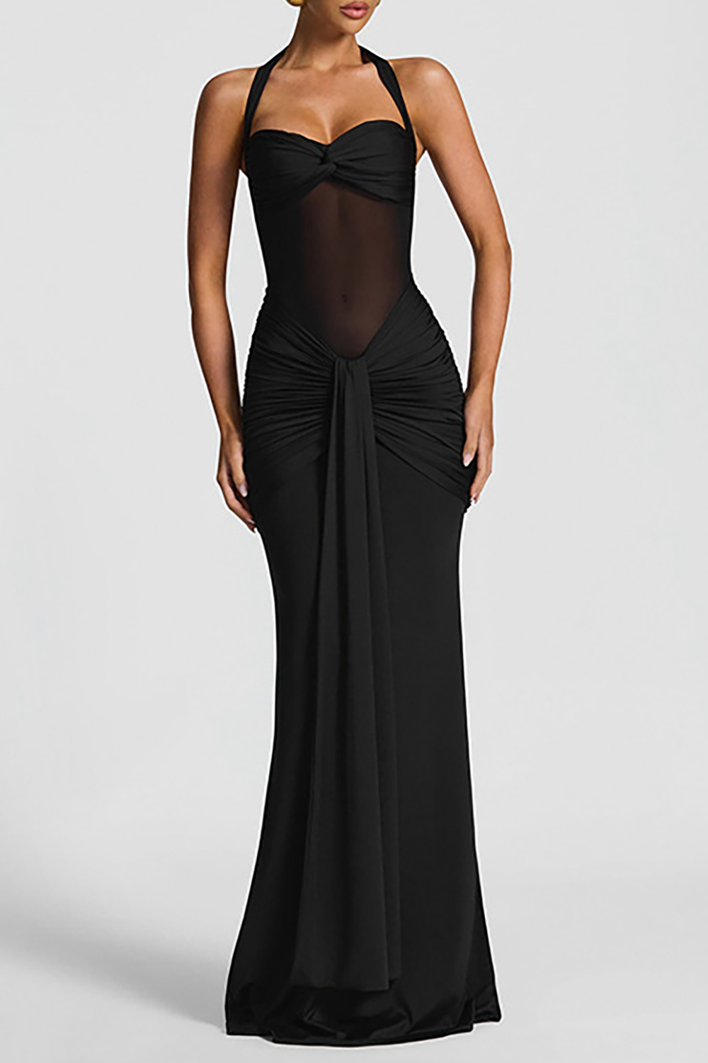 Woman wearing a black floor-length gown with a halter neckline, sheer midriff, and ruched detailing.
