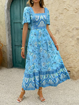 Front view of a woman in a blue floral print midi dress.