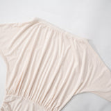 Close-up of the draped dolman sleeve and ruched waist of the off-the-shoulder mini dress.