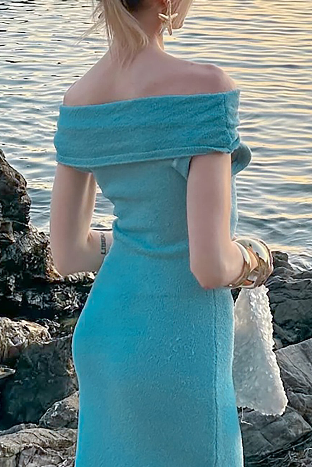 Back view of a woman in a turquoise off-the-shoulder maxi dress