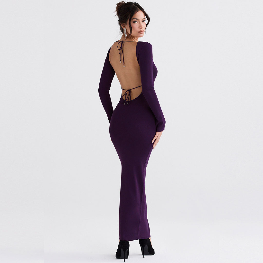 Back view of a woman in a long purple dress with an open back and tie closure.