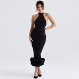 Woman wearing a black halter neck midi dress with a ruffled hem