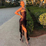woman posing in a black strapless dress outdoors