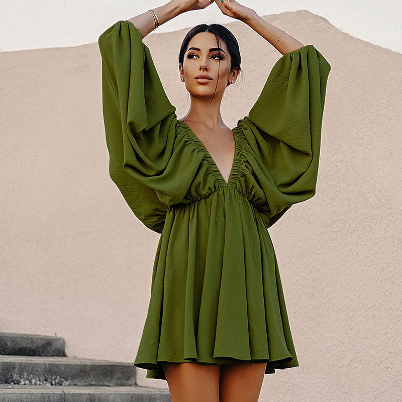 Woman in a green V-neck dress with flowing skirt