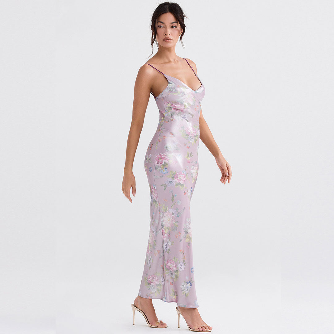Side view of a woman in a floral print slip dress, showcasing its fitted silhouette.