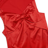 Close-up of the large satin bow detail on the back of a red dress.