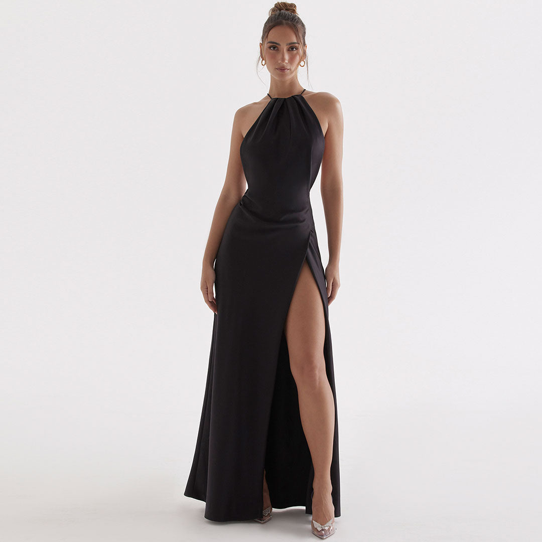 woman wearing a black floor-length halter dress with a high slit
