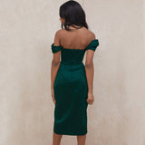 Back view of a woman in a dark green off-the-shoulder satin dress with a corset bodice and a high slit.