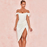 Front view of a woman in a white draped satin dress with an off-the-shoulder neckline