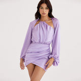 Woman wearing a lavender satin mini dress with a halter neckline and cut-out detail.