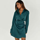 Woman wearing a teal satin long sleeve wrap mini dress from the front