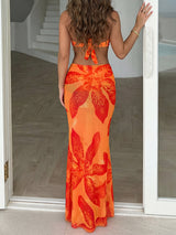 Woman wearing an orange strapless bikini top and a matching floral print sarong skirt, side view.