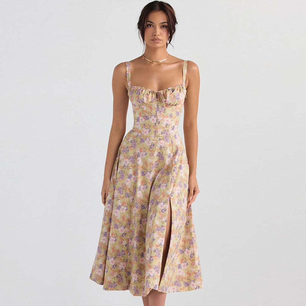 Woman wearing a yellow floral print midi dress with a sweetheart neckline and side slit