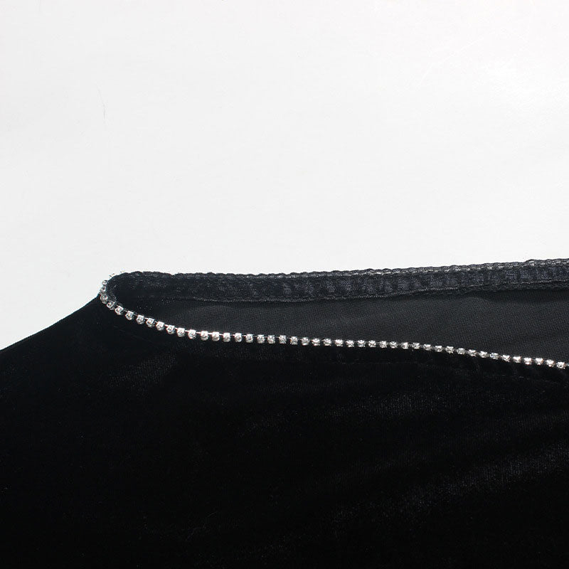 Detail shot of the embellished trim along the neckline of a black velvet dress.