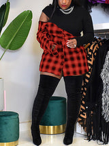 Woman wearing a black and red plaid mini dress with a black knit top and thigh-high black boots, showing off the off-the-shoulder detail