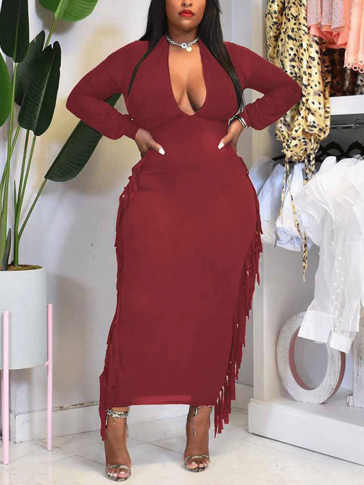 woman wearing a burgundy long-sleeved bodycon maxi dress with fringe trim and a plunging neckline
