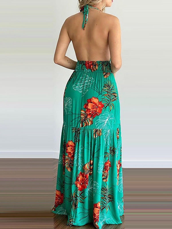 Back view of a woman wearing a green floral print maxi dress with a halter neck and open back.
