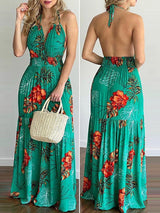 Front and back view of a woman wearing a green floral print maxi dress with a V-neck and halter neck.
