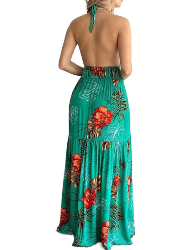 Back view of a woman wearing a green floral print maxi dress with a halter neck and open back.