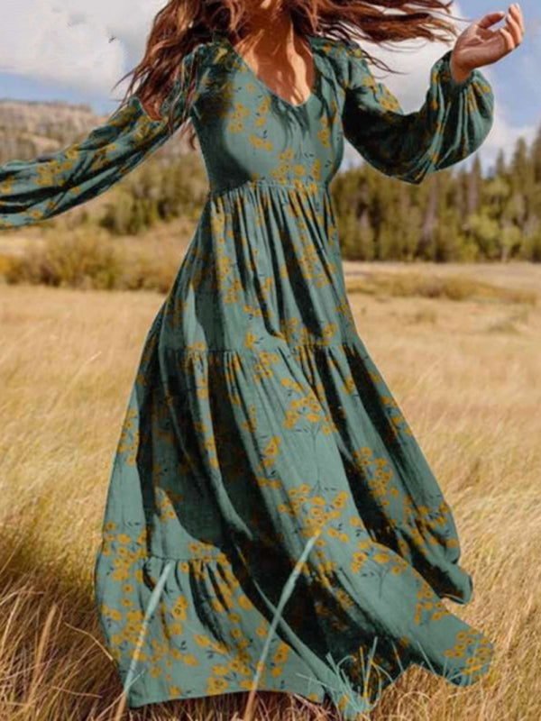 Woman wearing a long green floral maxi dress with bell sleeves in a field.