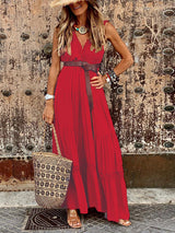A woman poses in a red bohemian-style maxi dress, featuring a deep V-neck, sleeveless design, and a flowing tiered skirt with delicate lace accents.