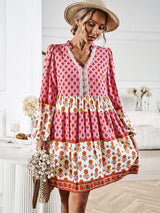 Back view of a woman wearing a pink and white floral print tiered mini dress.