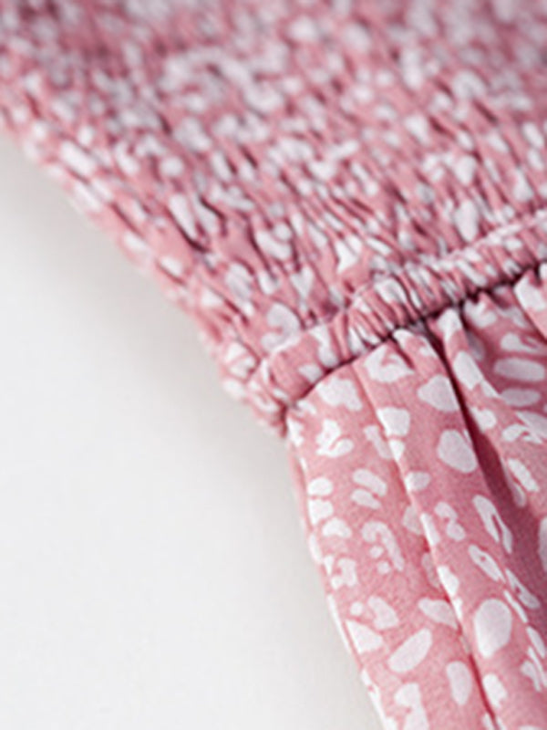Close-up of the smocked waist and tiered skirt of the pink floral dress.