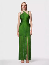 woman wearing a long green halter neck dress with tiered fringe and a high leg slit